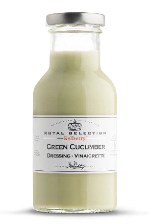 Glass bottle of green cucumber dressing with a white label on a white background